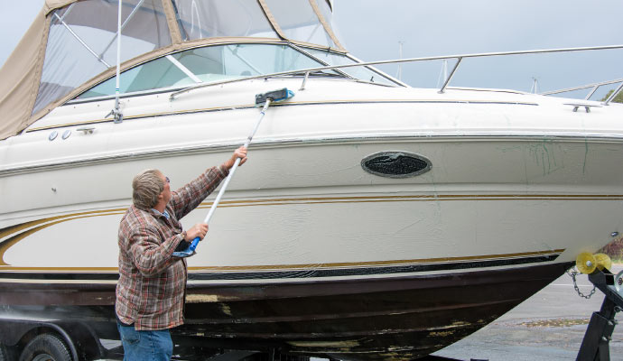 A person cleaning a boat using equipment