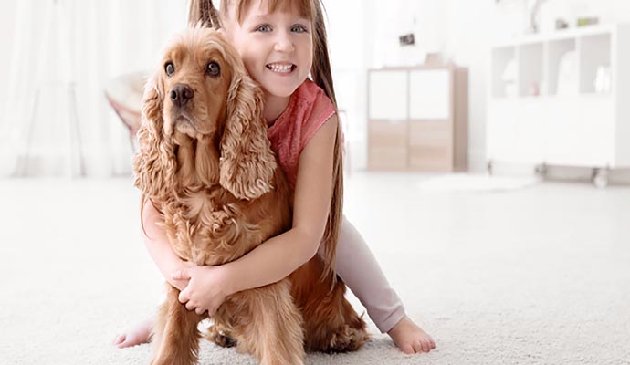 Children paying with puppy on carpet