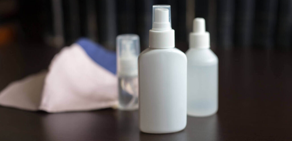 Cleaning clothes and small white spray bottles with green cleaning products from Masterkleen.
