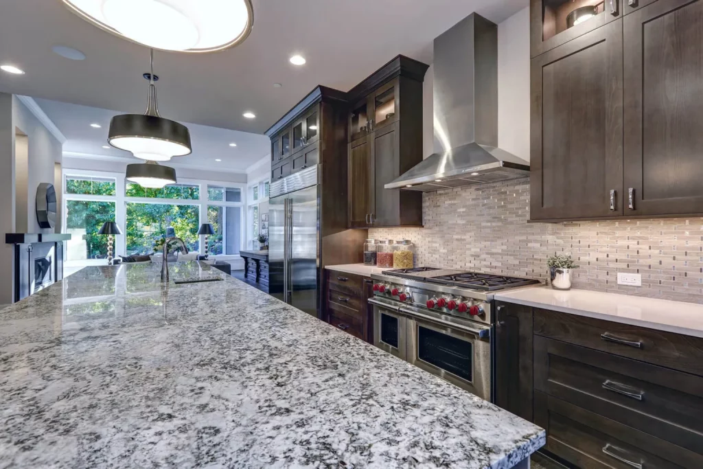 A modern kitchen with sleek granite counter tops and shiny stainless steel appliances after countertop restoration from Masterkleen